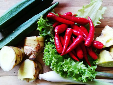 Colorful assortment of fresh vegetables and spices, including chili peppers, ginger, and okra.